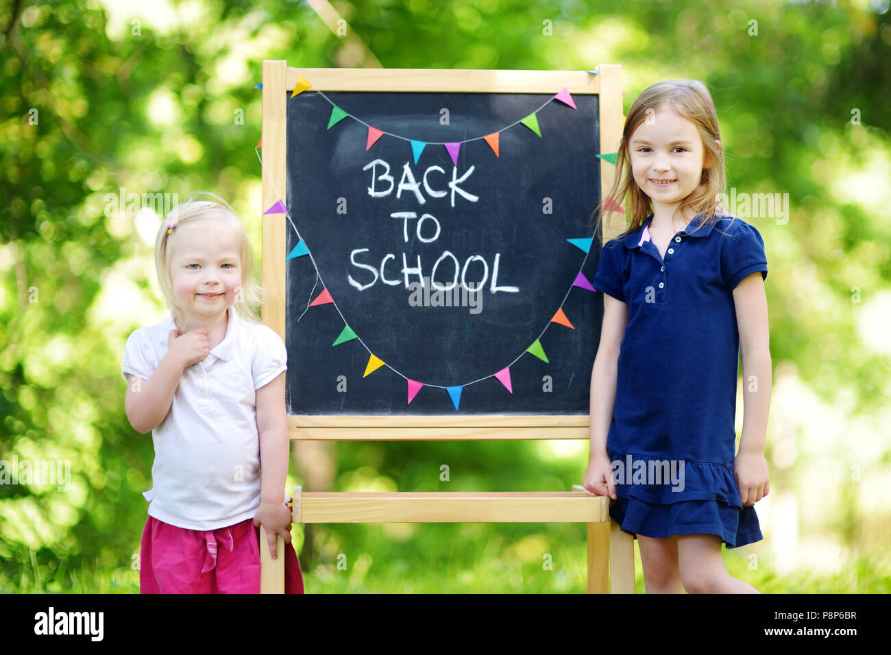 Two adorable little sisters feeling very excited about going back to school Stock Photo