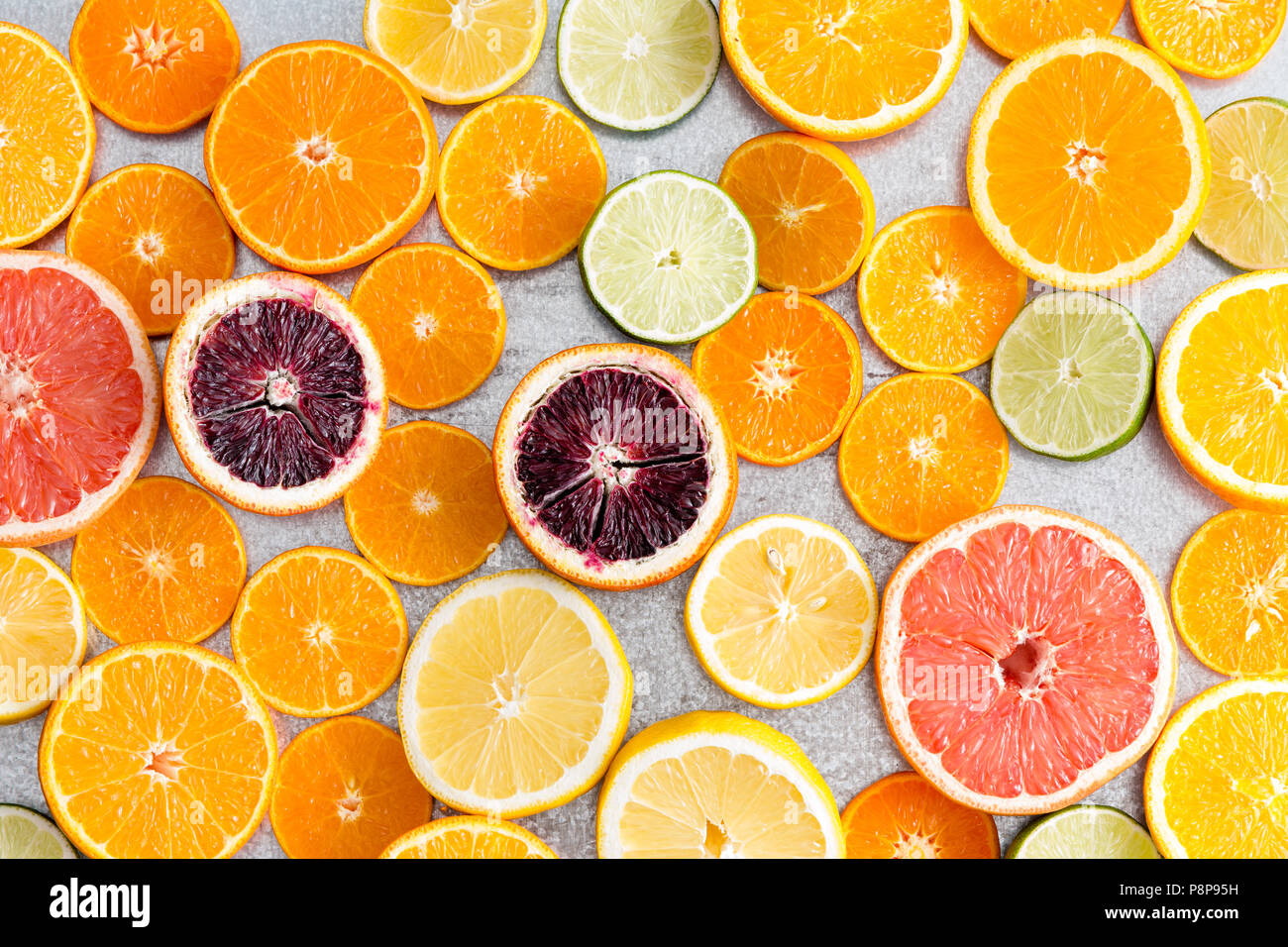 Colorful fresh cut citrus fruit background with a large assortment of halved different fruits showing the juicy pulp in a full frame view Stock Photo