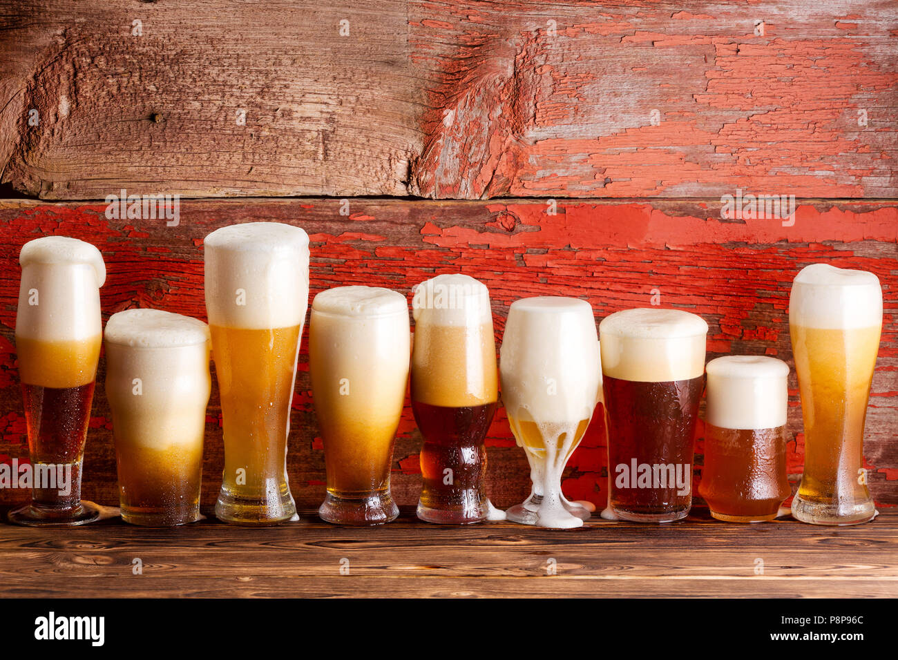 Multiple Frothy Lager Beer Pints On Wooden Bar Bench Top With A