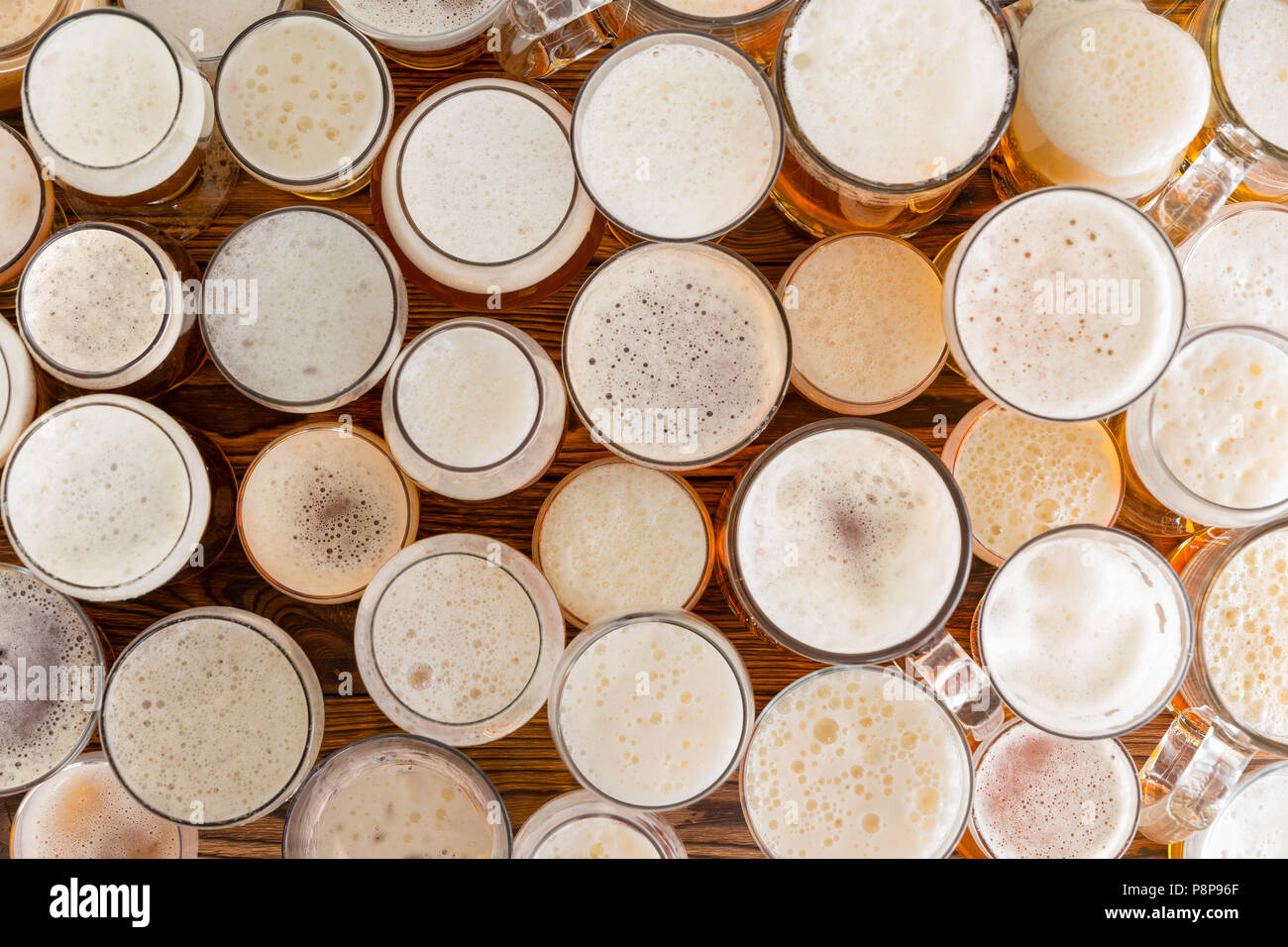An Assortment Of Full Frothy Beer Glasses And Sizes On A Bar