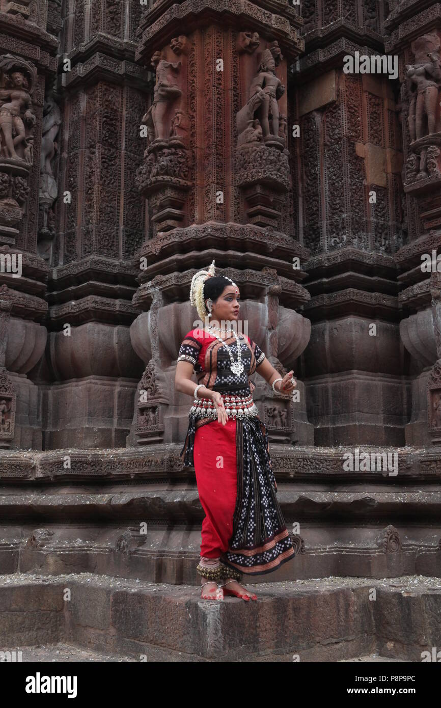 odissi is one of the eight classical dance forms of india,from the state of odisha.here the dancer poses before temples with sculptures Stock Photo