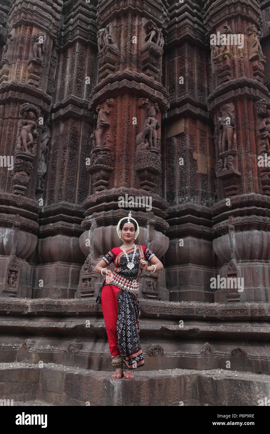 odissi is one of the eight classical dance forms of india,from the state of odisha.here the dancer poses before temples with sculptures Stock Photo