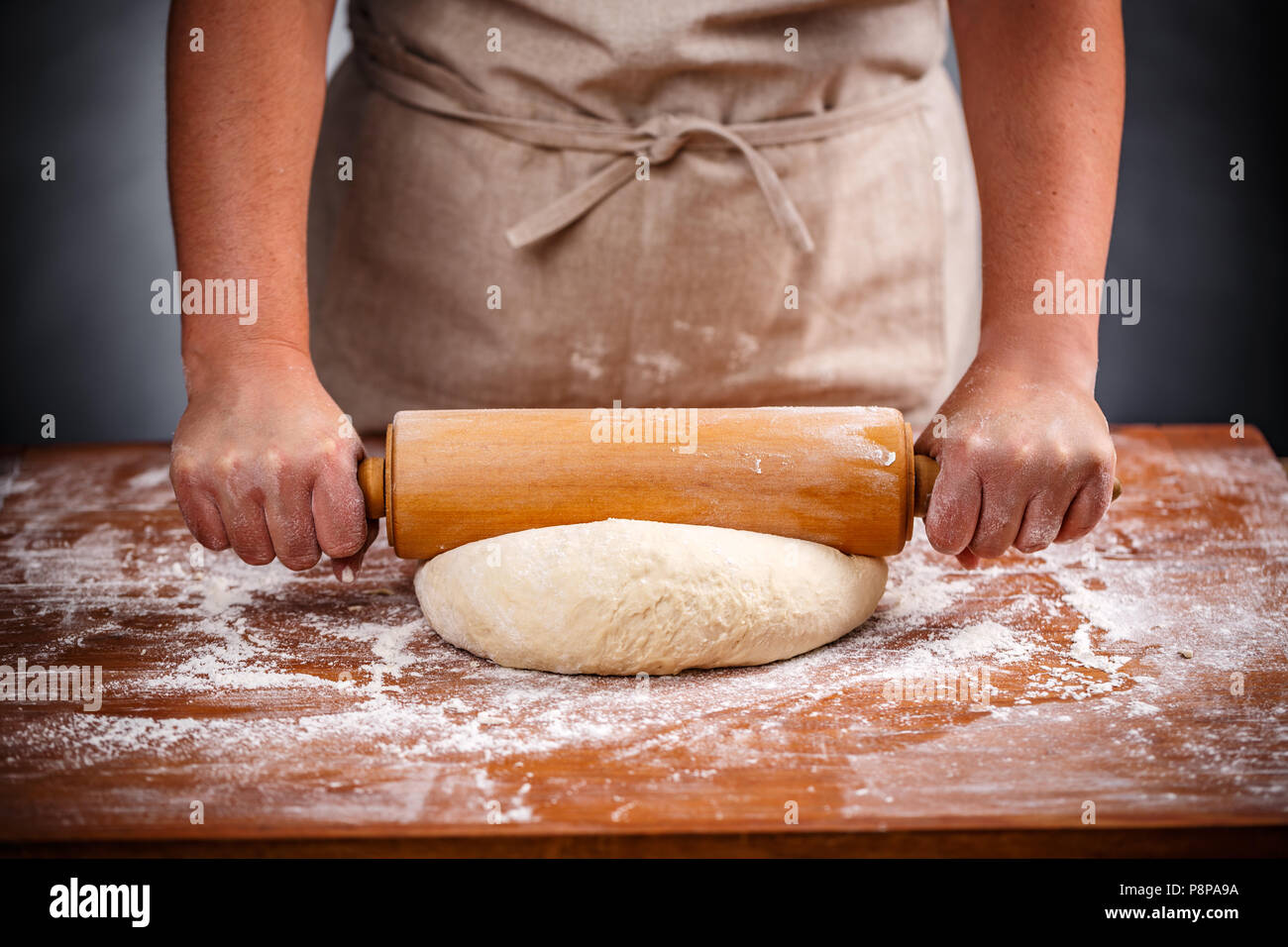 Housewife flattening a dough with a rolling pin Stock Photo Alamy