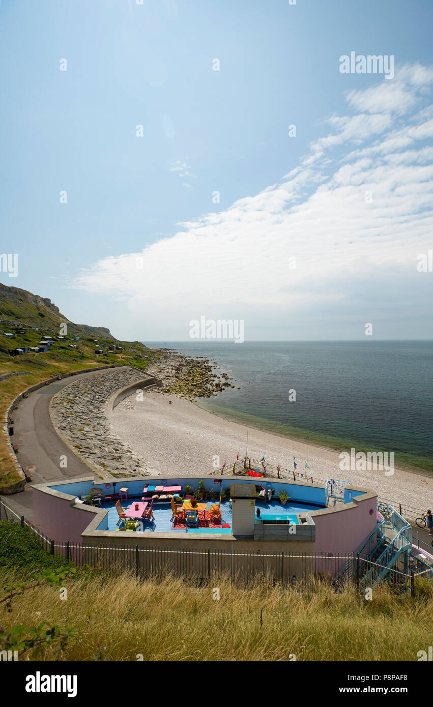 A view of the rooftop terrace of the Quiddles Cafe in the foreground overlooking Chesil Cove adjacent to the Isle of Portland and the eastern-most end Stock Photo
