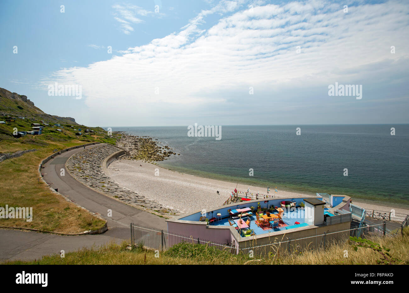 A view of the rooftop terrace of the Quiddles Cafe in the foreground overlooking Chesil Cove adjacent to the Isle of Portland and the eastern-most end Stock Photo