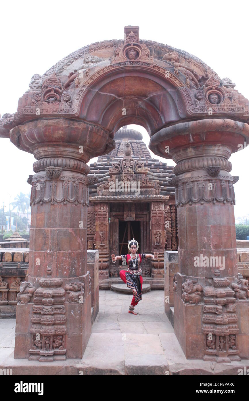 odissi is one of the eight classical dance forms of india,from the state of odisha.here the dancer poses before temples with sculptures Stock Photo