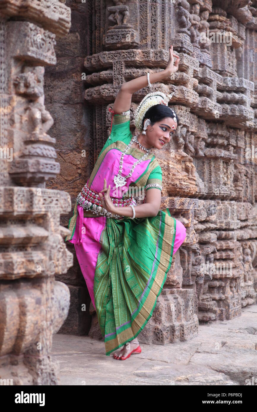 odissi is one of the eight classical dance forms of india,from the state of odisha.here the dancer poses before temples with sculptures Stock Photo