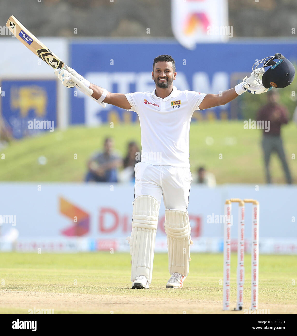 Sri Lankan cricketer Dimuth Karunaratne raises his bat and helmet in celebration after scoring a century (100 runs) during the first day of the opening Test match between Sri Lanka and South Africa at the Galle International Cricket Stadium in Galle on July 12, 2018 (Photo by Lahiru Harshana / Pacific Press) Stock Photo