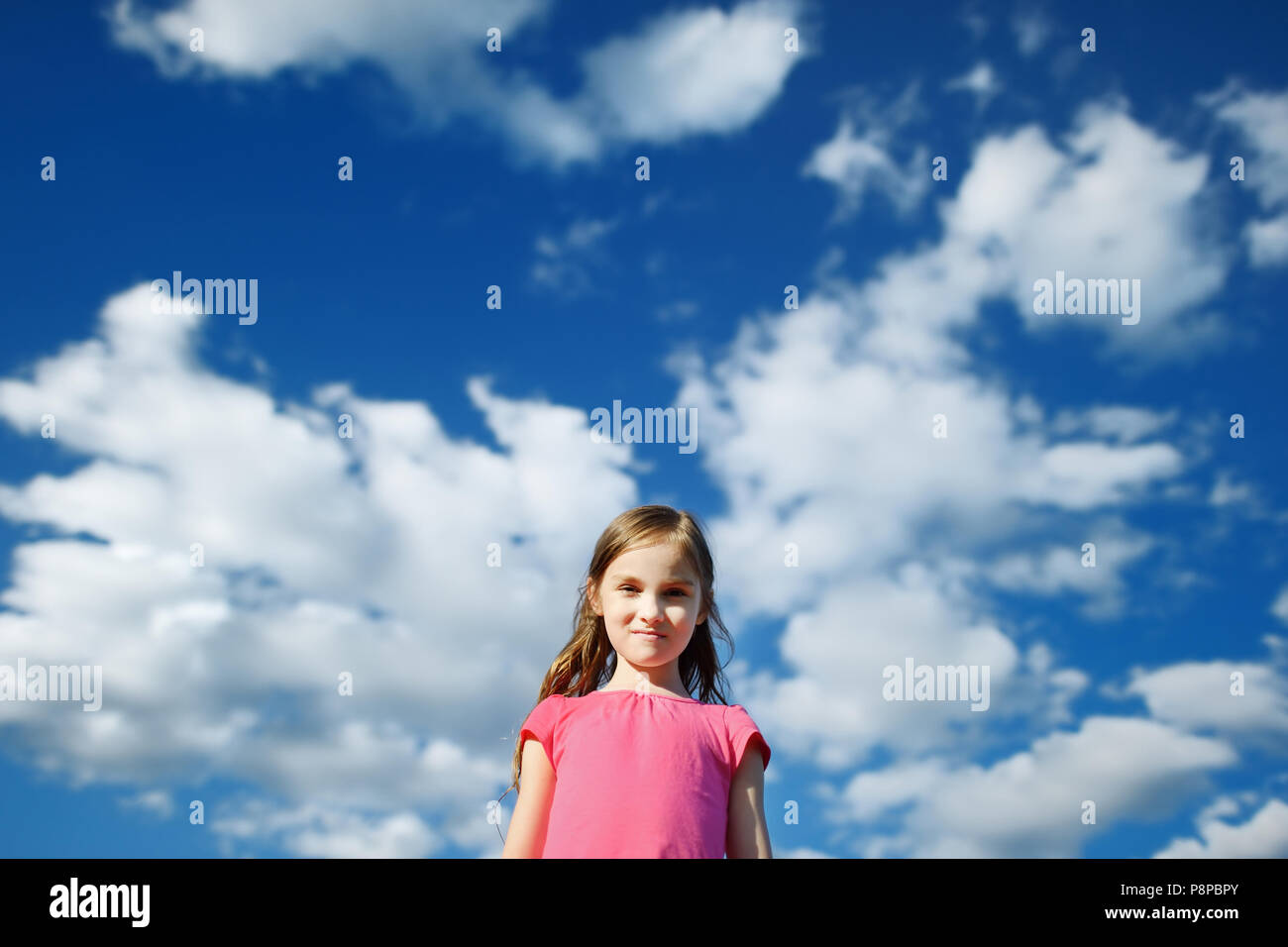 Cute little girl on a cloudy background Stock Photo - Alamy