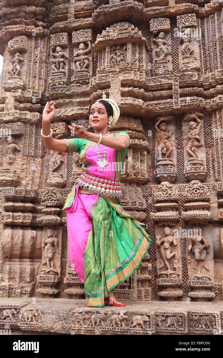 odissi is one of the eight classical dance forms of india,from the state of odisha.here the dancer poses before temples with sculptures Stock Photo