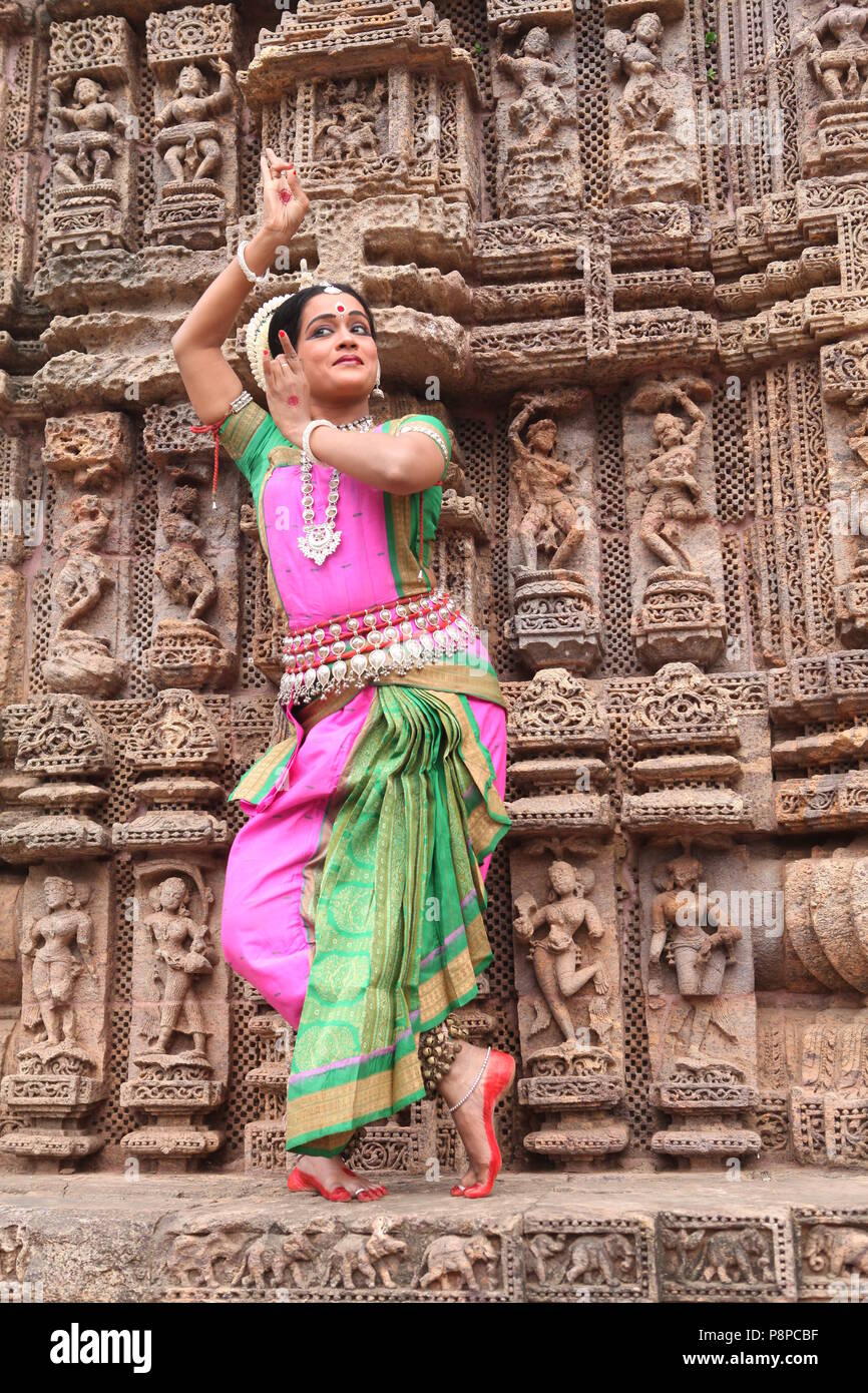 odissi is one of the eight classical dance forms of india,from the state of odisha.here the dancer poses before temples with sculptures Stock Photo