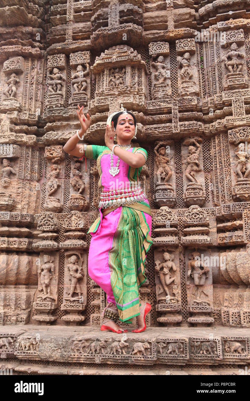 odissi is one of the eight classical dance forms of india,from the state of odisha.here the dancer poses before temples with sculptures Stock Photo