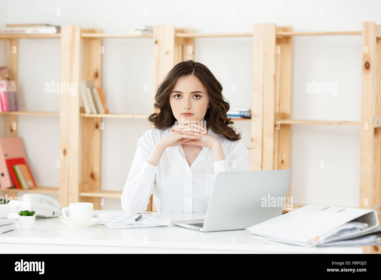 Young attractive woman at a modern office desk, working with laptop and ...