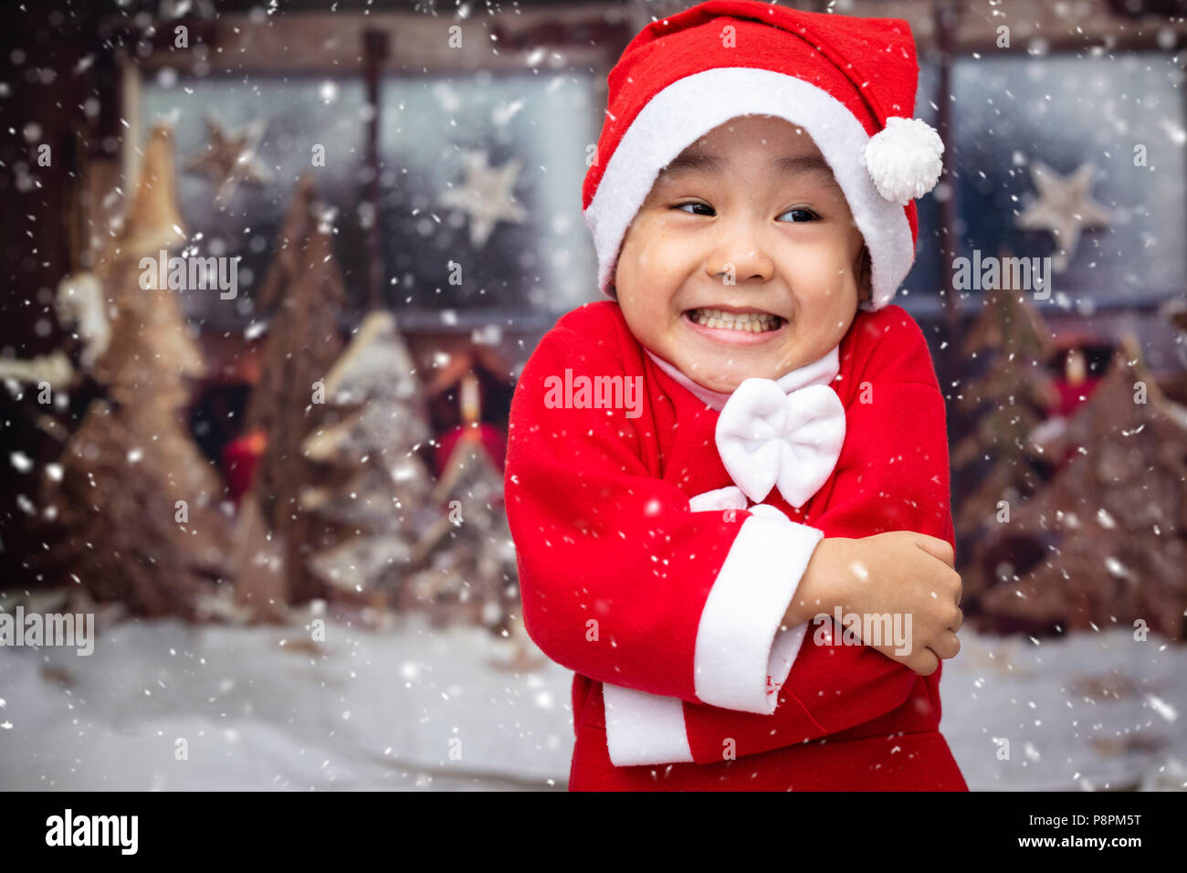 Asian Chinese little girl playing with snowflakes outdoor during christmas eve Stock Photo