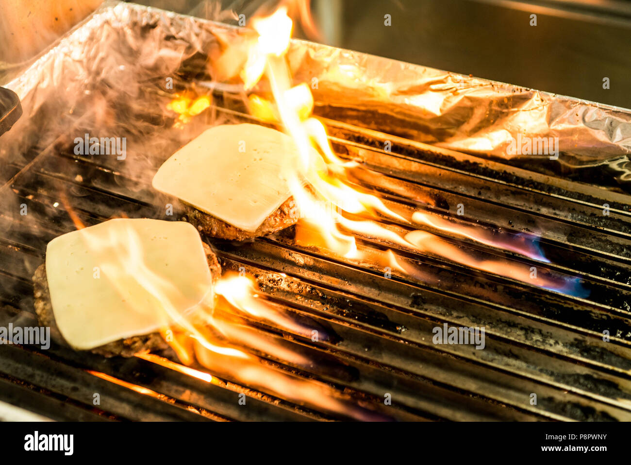hamburger beef patty - grilled meat and cheese on a barbecue grill fire ...