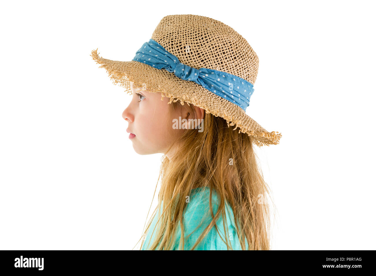 Side view studio shot portrait of a cute serious little girl wearing straw summer hat against white background for copy space Stock Photo