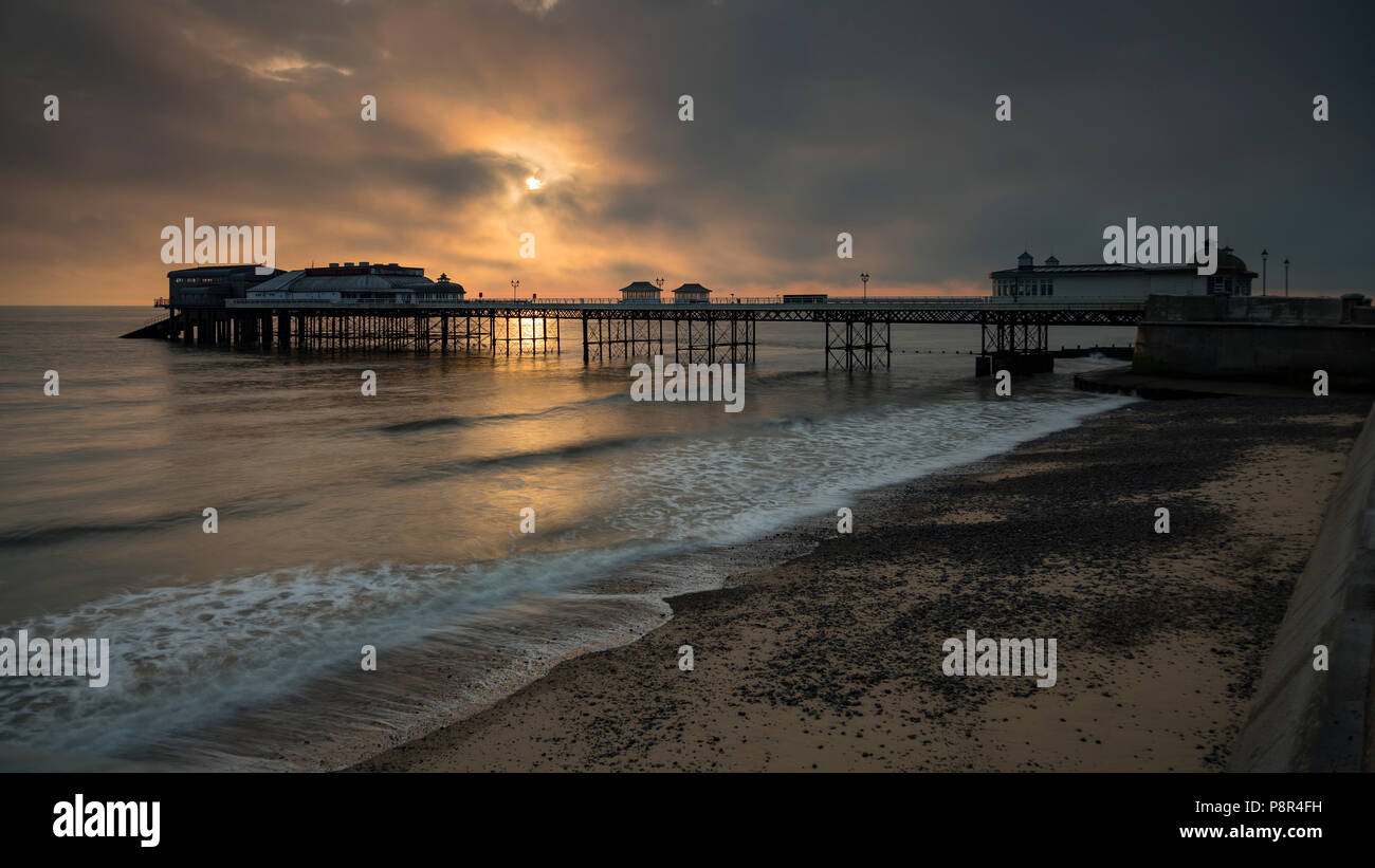 Cromer pier with clouds at sunrise, Norfolk, England Stock Photo