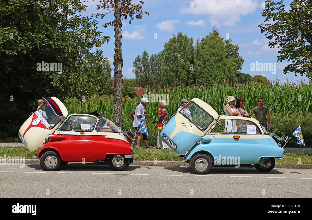 GARCHING, GERMANY-JULY 8, 2018. Two Vintage cars BMW Isetta 300 bicolor red and blue with creamy white top, with open door and open sun roof ready for Stock Photo