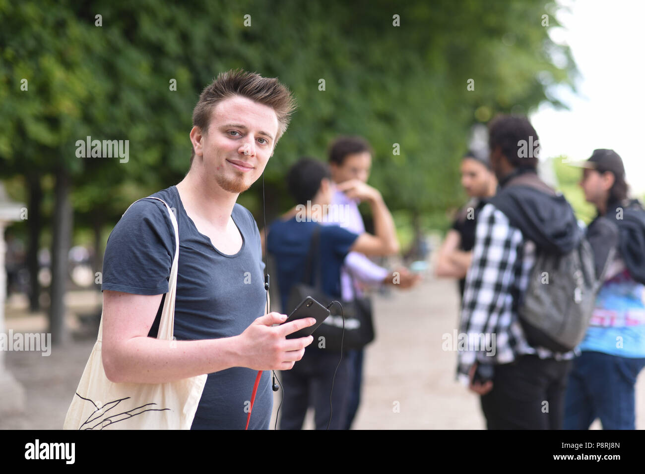 July 14, 2016 - Paris, France: Portrait of Raphael Candelaresi, one of the organizers of the mass Pokemon hunt in the Luxembourg Garden in central Paris. Hundreds of players of the new Pokemon Go game showed up to take part in a massive hunt despite the authorities' attempt to cancel the event. Despite playing mostly solo, the Pokemon Go users enjoyed to interact and meet other players. Millions of users have already downloaded the game, which requires users to catch on-screen pokemon characters using their real-world location. Des jeunes participent a une chasse au Pokemons dans le jardin du  Stock Photo