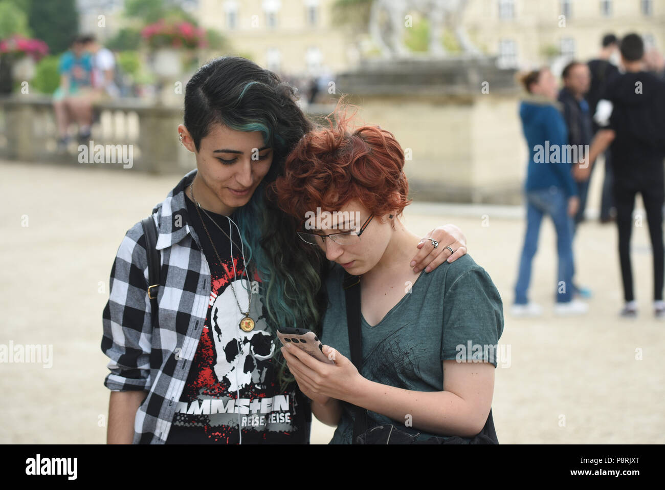 July 14, 2016 - Paris, France: French arts students Calypso (L), 17 yo, and Lorenz, 18yo, take part in a mass Pokemon hunt in the Luxembourg Garden in central Paris. Hundreds of players of the new Pokemon Go game showed up to take part in a massive hunt despite the authorities' attempt to cancel the event. Despite playing mostly solo, the Pokemon Go users enjoyed to interact and meet other players. Millions of users have already downloaded the game, which requires users to catch on-screen pokemon characters using their real-world location.  Des jeunes participent a une chasse au Pokemons dans  Stock Photo