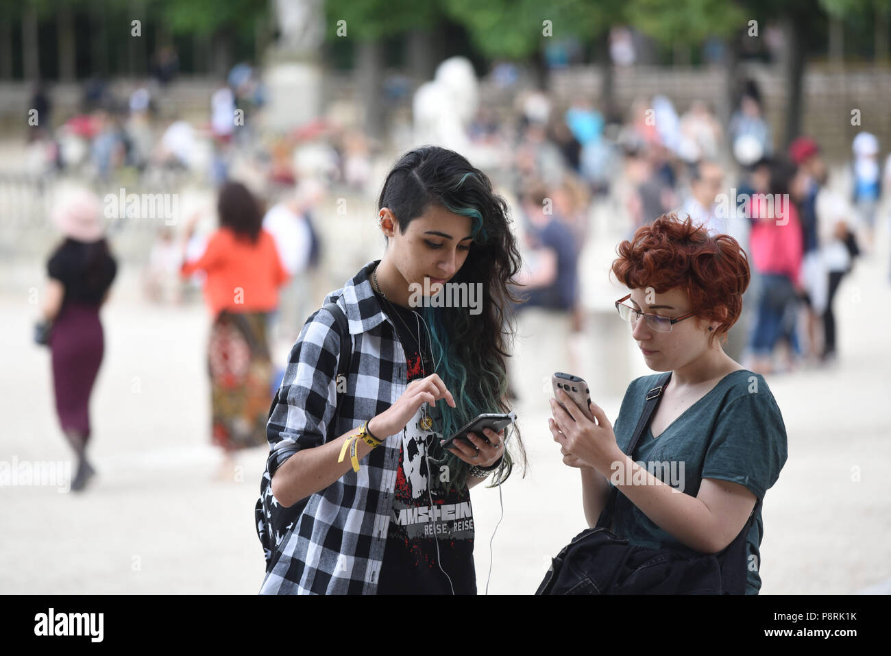 July 14, 2016 - Paris, France: French arts students Calypso (L), 17 yo, and Lorenz, 18yo, take part in a mass Pokemon hunt in the Luxembourg Garden in central Paris. Hundreds of players of the new Pokemon Go game showed up to take part in a massive hunt despite the authorities' attempt to cancel the event. Despite playing mostly solo, the Pokemon Go users enjoyed to interact and meet other players. Millions of users have already downloaded the game, which requires users to catch on-screen pokemon characters using their real-world location. *** FRANCE OUT / NO SALES TO FR Stock Photo