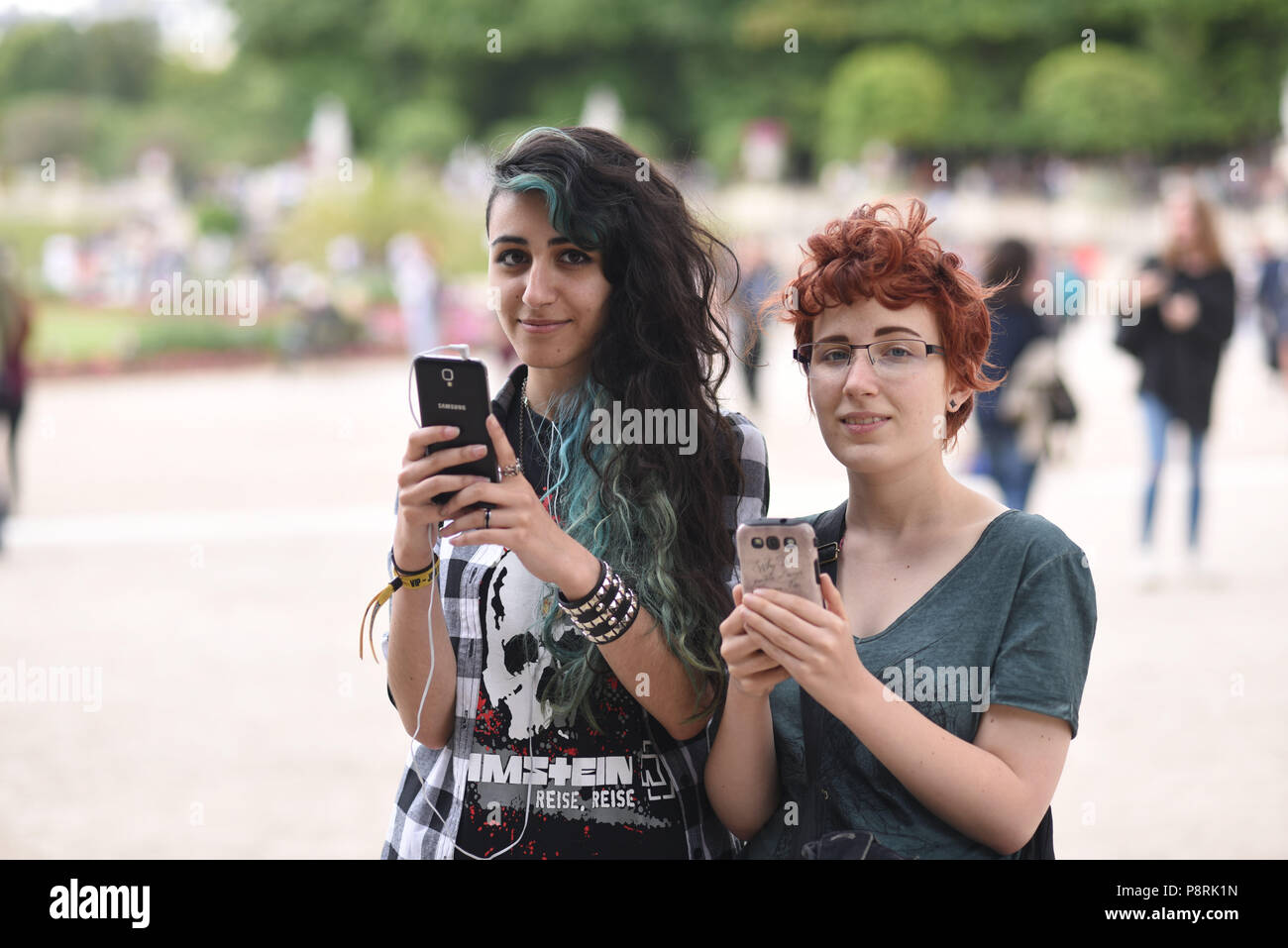 July 14, 2016 - Paris, France: French arts students Calypso (L), 17 yo, and Lorenz, 18yo, take part in a mass Pokemon hunt in the Luxembourg Garden in central Paris. Hundreds of players of the new Pokemon Go game showed up to take part in a massive hunt despite the authorities' attempt to cancel the event. Despite playing mostly solo, the Pokemon Go users enjoyed to interact and meet other players. Millions of users have already downloaded the game, which requires users to catch on-screen pokemon characters using their real-world location. Des jeunes participent a une chasse au Pokemons dans l Stock Photo