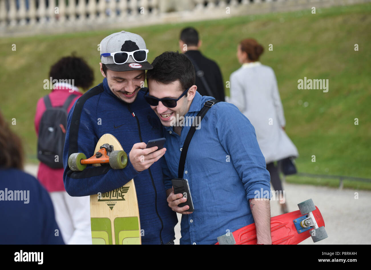 July 14, 2016 - Paris, France: Youths take part in a mass Pokemon hunt in the Luxembourg Garden in central Paris. Hundreds of players of the new Pokemon Go game showed up to take part in a massive hunt despite the authorities' attempt to cancel the event. Despite playing mostly solo, the Pokemon Go users enjoyed to interact and meet other players. Millions of users have already downloaded the game, which requires users to catch on-screen pokemon characters using their real-world location.  Des jeunes participent a une chasse au Pokemons dans le jardin du Luxembourg avec l'application Pokemon G Stock Photo