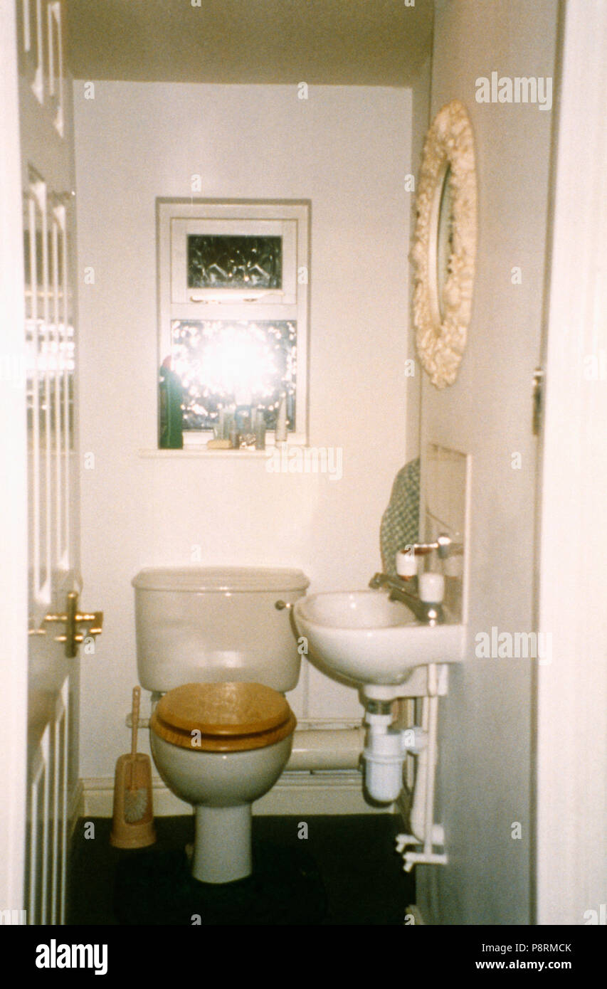 Toilet and basin in dated cloakroom before renovation Stock Photo