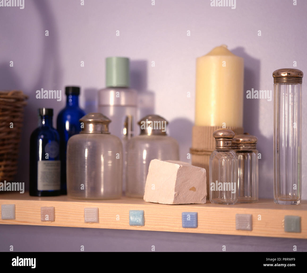 Collection of silver topped storage bottles on bathroom shelf Stock Photo