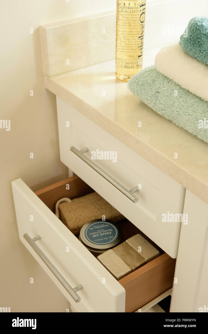Close-up of pile of towels on vanity unit with open storage drawer Stock Photo
