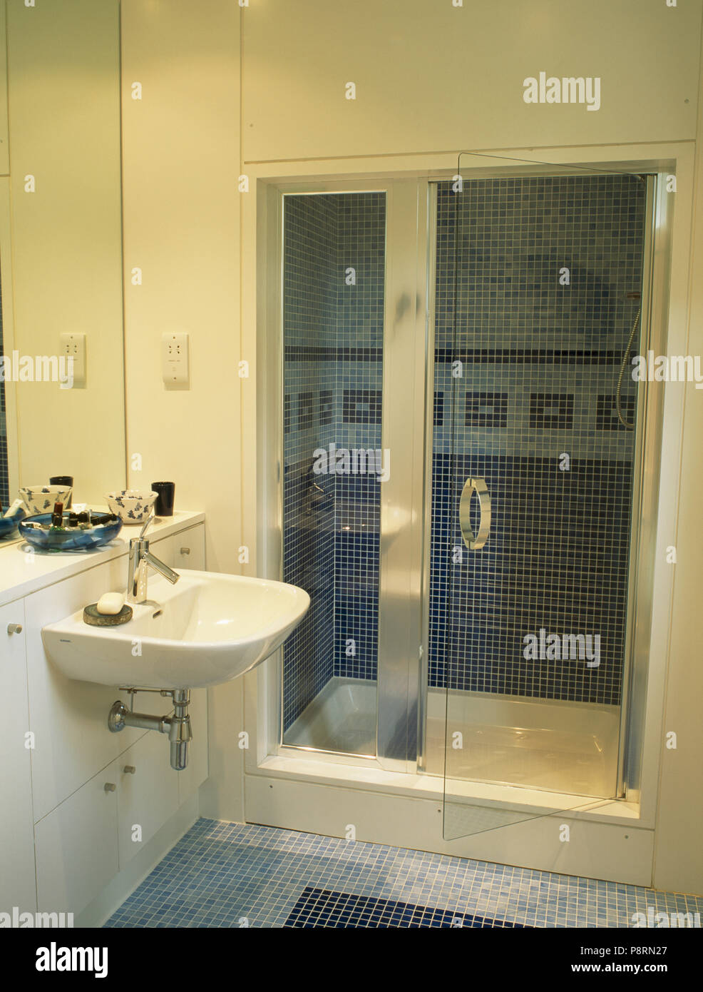 Glass doors on shower cabinet in modern white bathroom Stock Photo