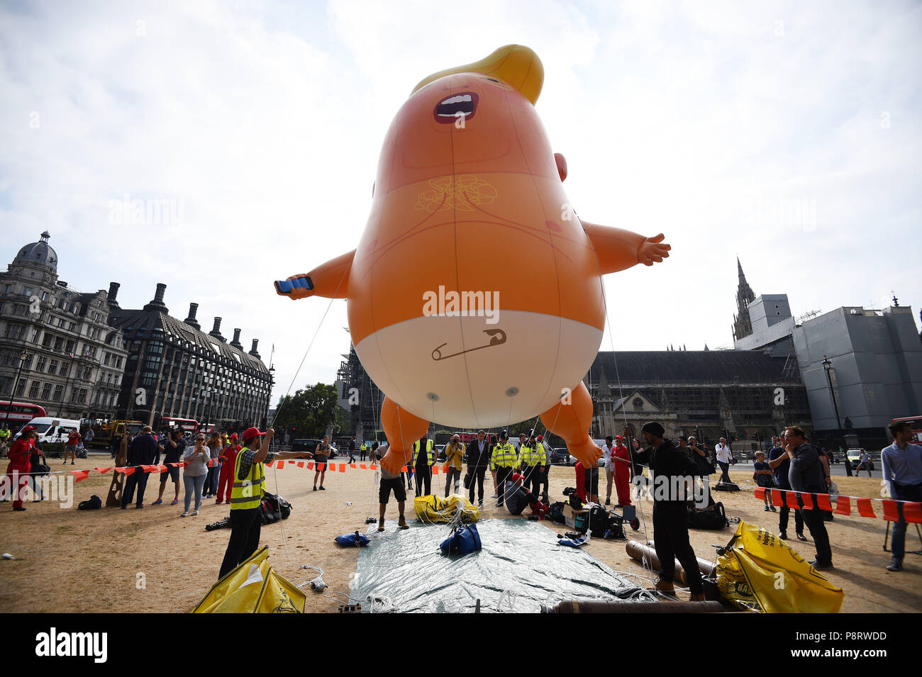 A 'Baby Trump' balloon rises after being inflated in London's Parliament Square, as part of the protests against the visit of US President Donald Trump to the UK. Stock Photo