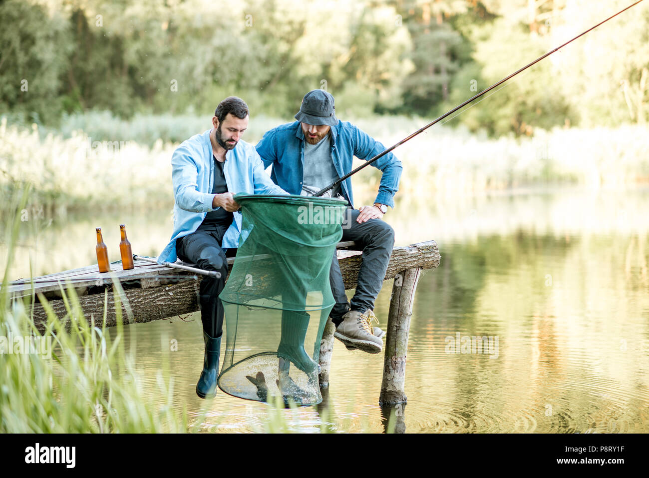 Two friends in a small fishing boat on a lake Stock Photo - Alamy