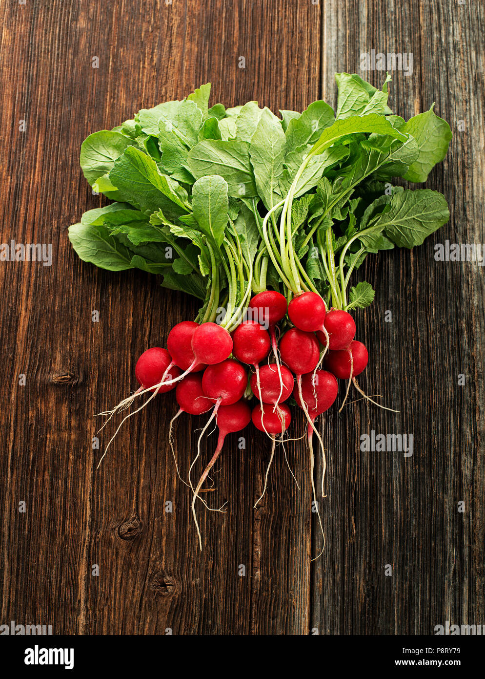 Fresh red radishes on wooden background close up Stock Photo