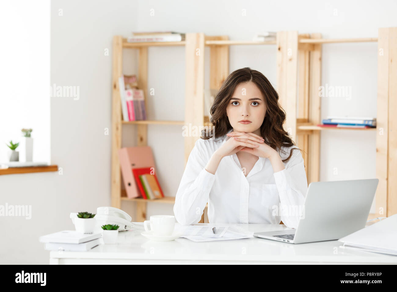Young attractive woman at a modern office desk, working with laptop and ...