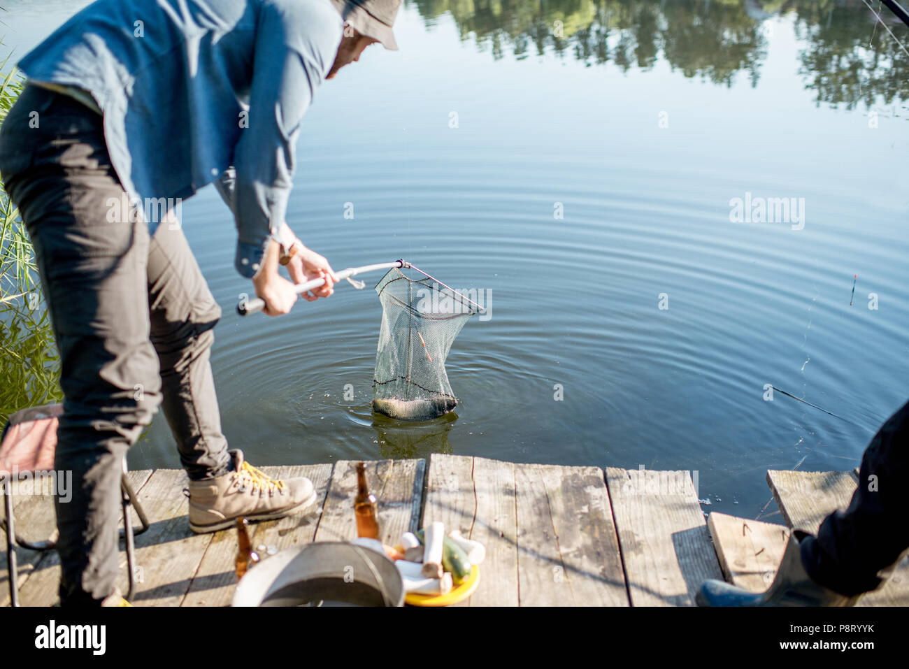Fisherman catching big fish with fishing net on the lake in the morning  Stock Photo - Alamy
