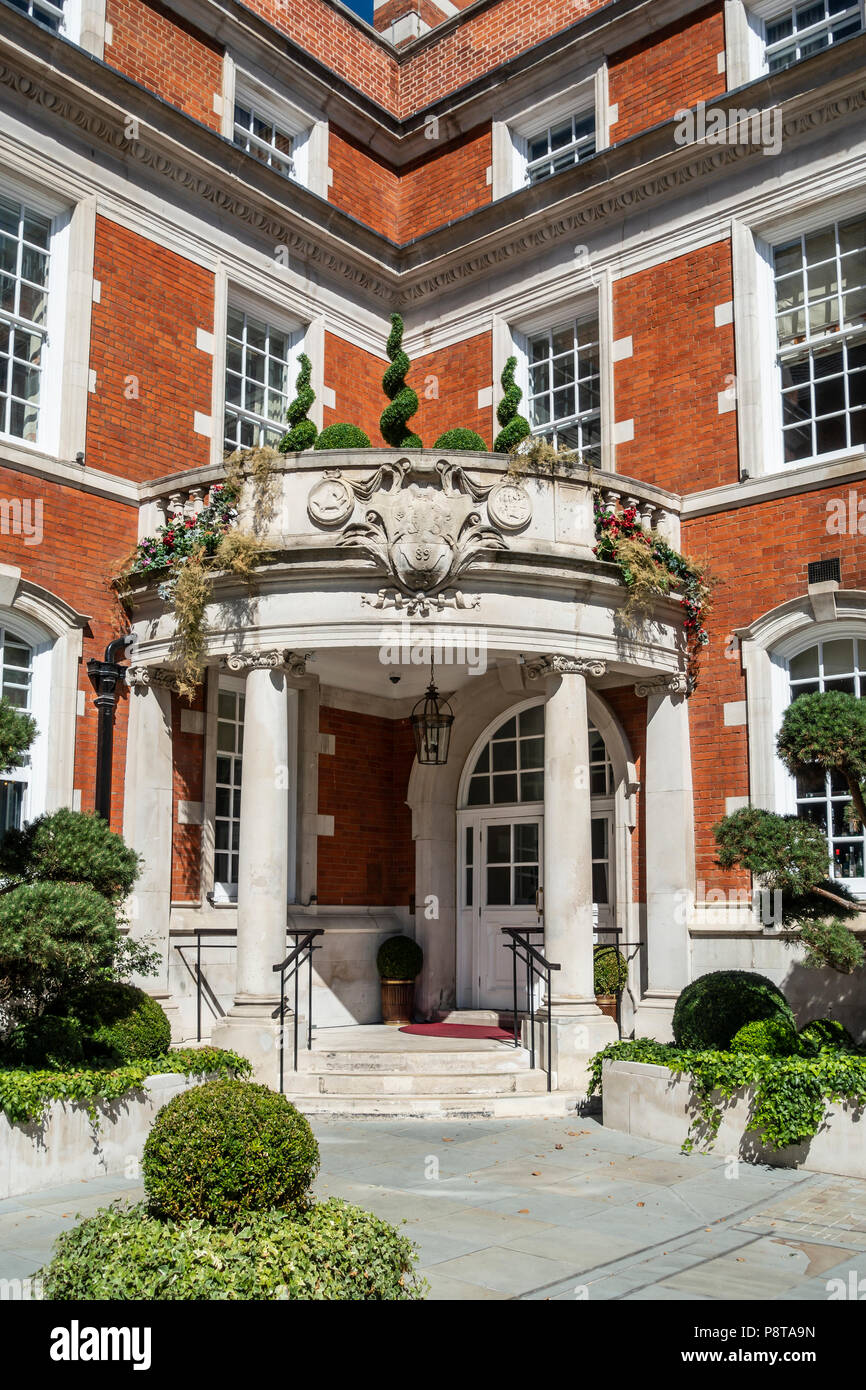 Entrance door to the Indian owned, five-star LaLiT hotel in London, England in the former St Olave's School. Topiary, cloud-pruned trees, box balls. Stock Photo