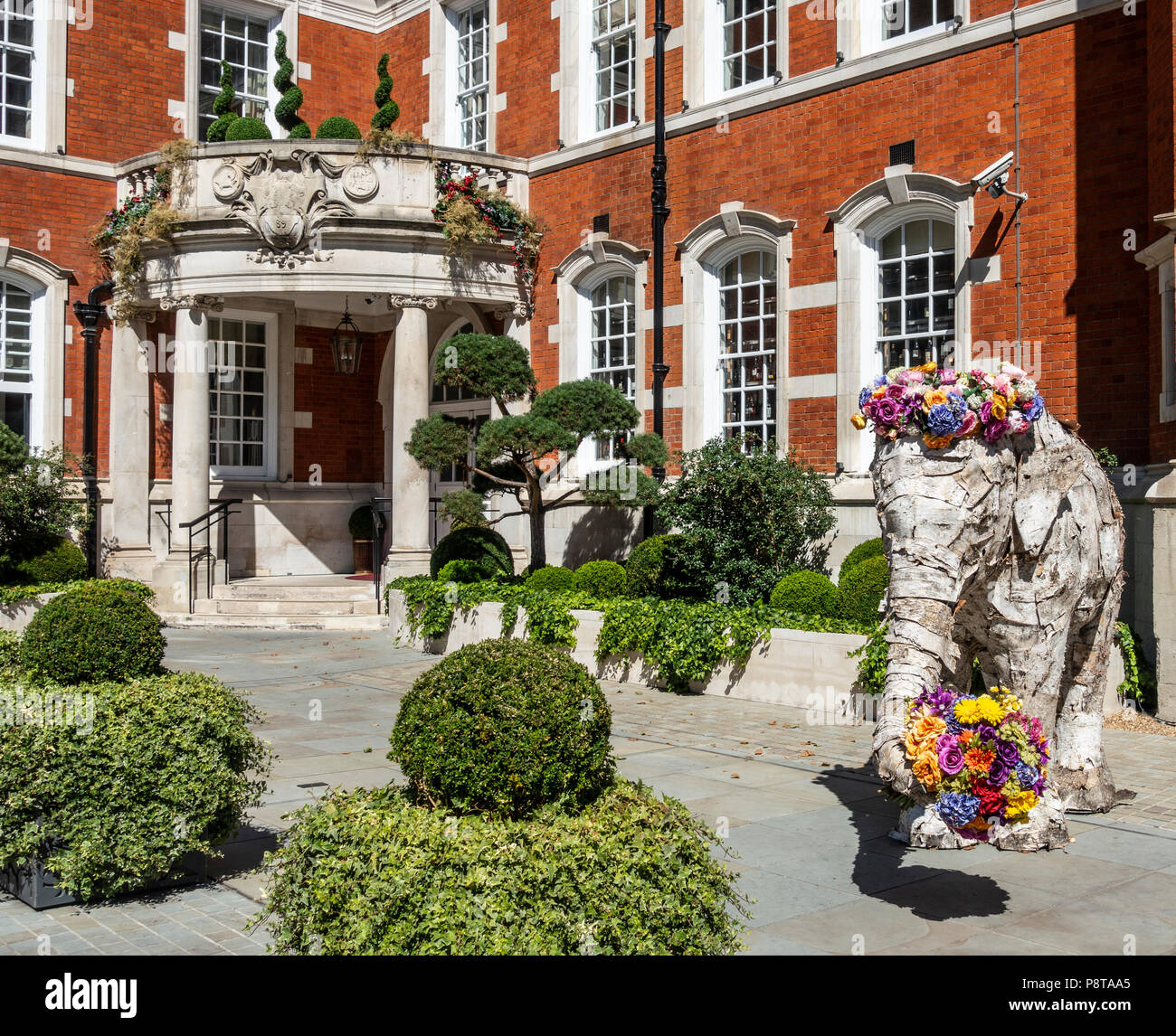 Main entrance to the Indian-owned five star LaLit Hotel in central London, with part of the garden and a welcoming elephant sculpture Stock Photo