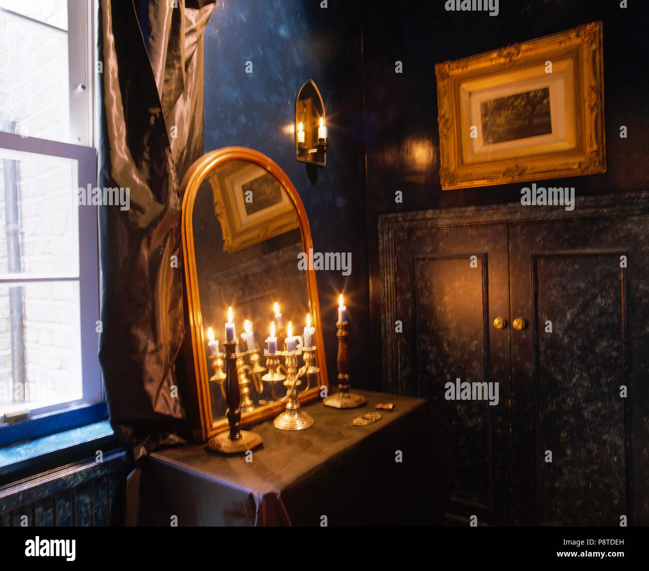 Close Up Of Lighted Candles In Brass Candlesticks In Front