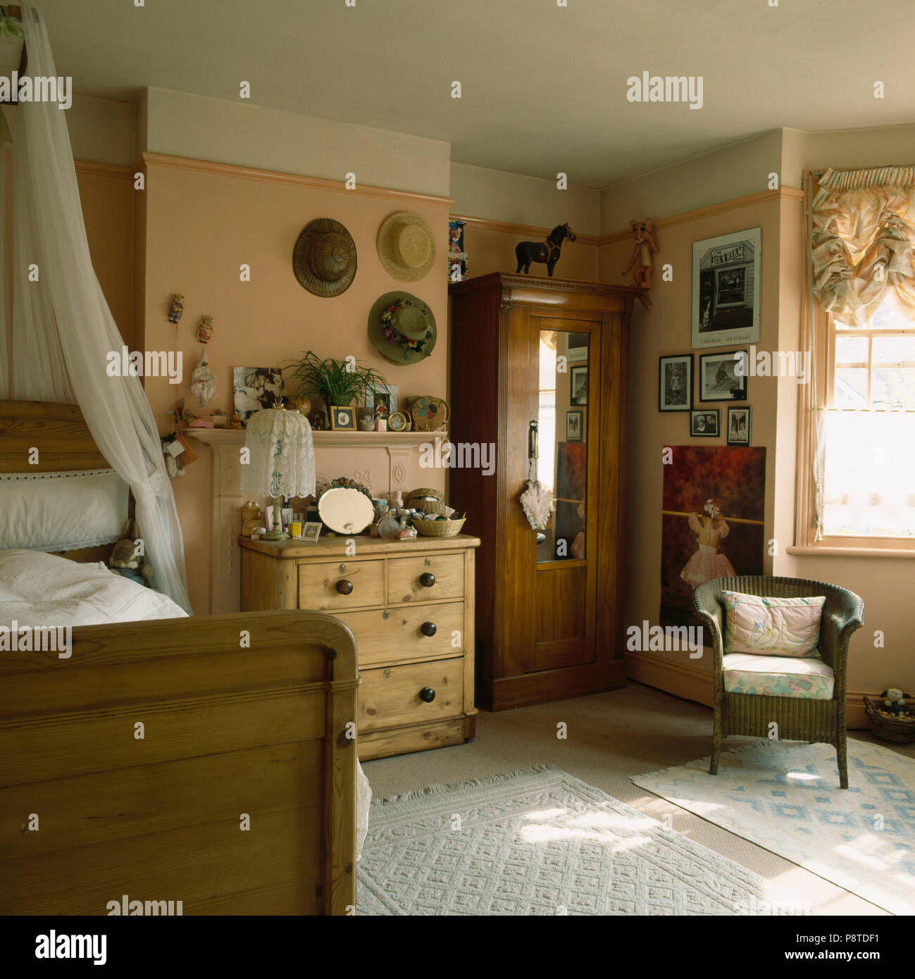 Pine Chest Of Drawers And White Voile Drapes Over Wooden Bed