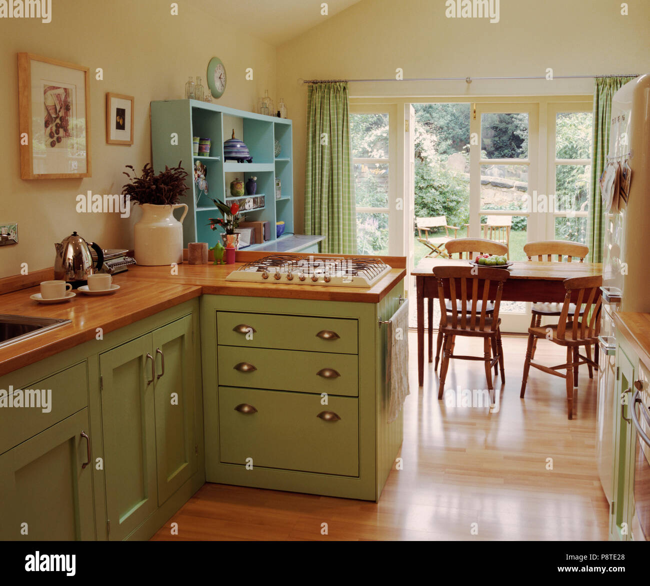 Wooden Flooring In Cream Kitchen Dining Room With Pastel Green