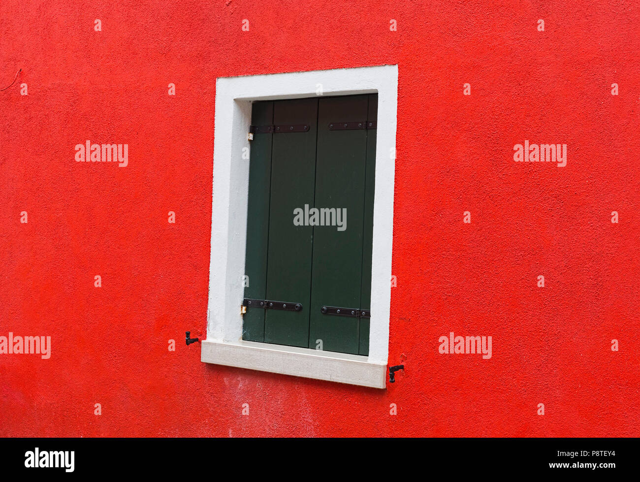 Window on bright red wall Burano Italy Stock Photo