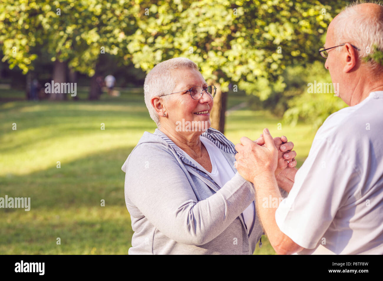 Happy family - Hands of senior couple during walk in park on sunny day close up Stock Photo