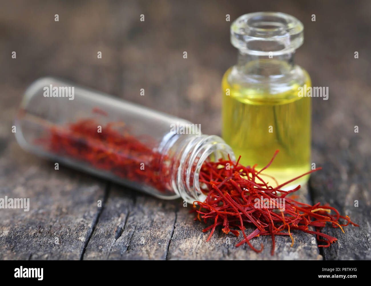 Closeup of Saffron with extract in a bottle on natural surface Stock Photo