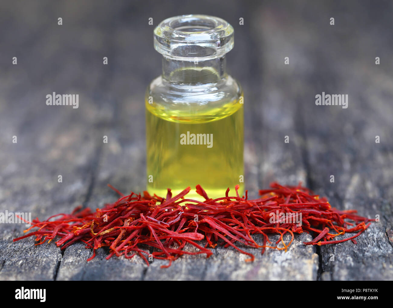 Closeup of Saffron with extract in a bottle on natural surface Stock Photo