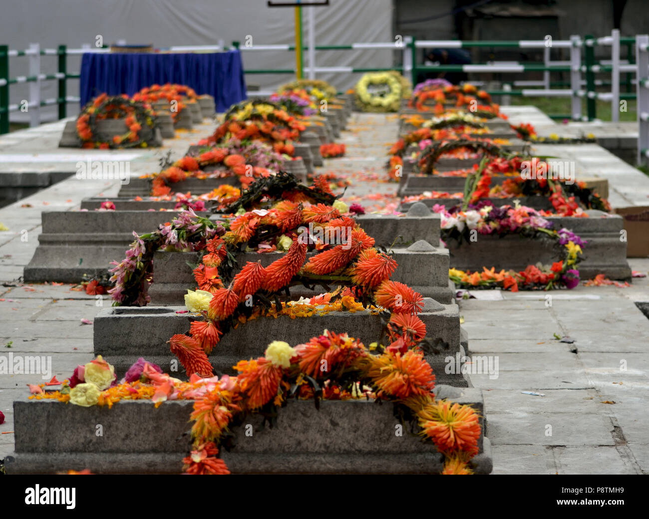 Srinagar, Kashmir. 13th July, 2018.Wreaths can be seen laying on graves at Martyr's graveyard in Srinagar, the summer capital of Indian controlled Kashmir, India, during a ceremony held to mark the martyrdom anniversary of Kashmiris slain by the army of a Hindu king. Indian Authorities in Srinagar deployed thousands of security personnel in the main city of Srinagar to prevent the anti-Indian protests in the downtown area of Srinagar. Every year on 13th July Kashmir observes the martyrdom anniversary of 23 Muslims which were killed by the forces of Maharaja Hari Singh in 1931 during his rule. Stock Photo