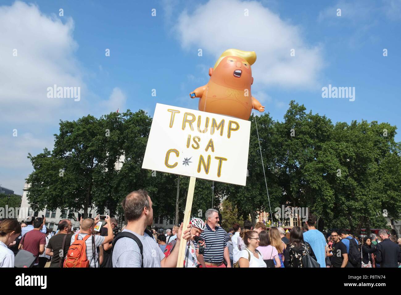 London 13th July 2018: A six metre high helium filled inflatable of President Trump depicted as a giant angry orange baby  wearing a nappie is raised over Parliament Square by activist protesting  his visit to the UK. Credit: Claire Doherty/Alamy Live News Stock Photo