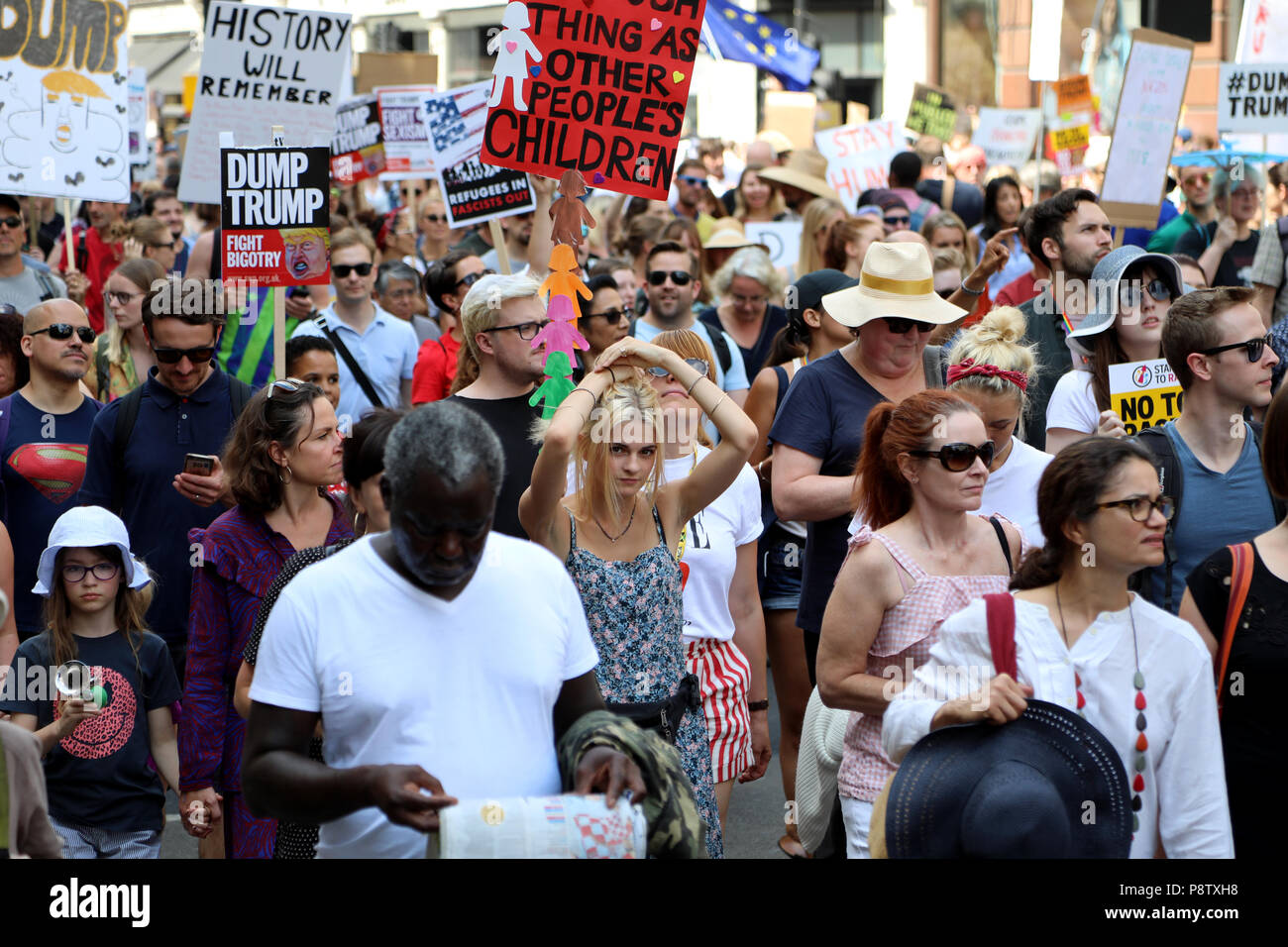 London, UK – July 13, 2018: A young woman adjusts her hair while taking part in a demonstration to protest against US president Donald Trump, during his visit to the country Credit: Dominic Dudley/Alamy Live News Stock Photo