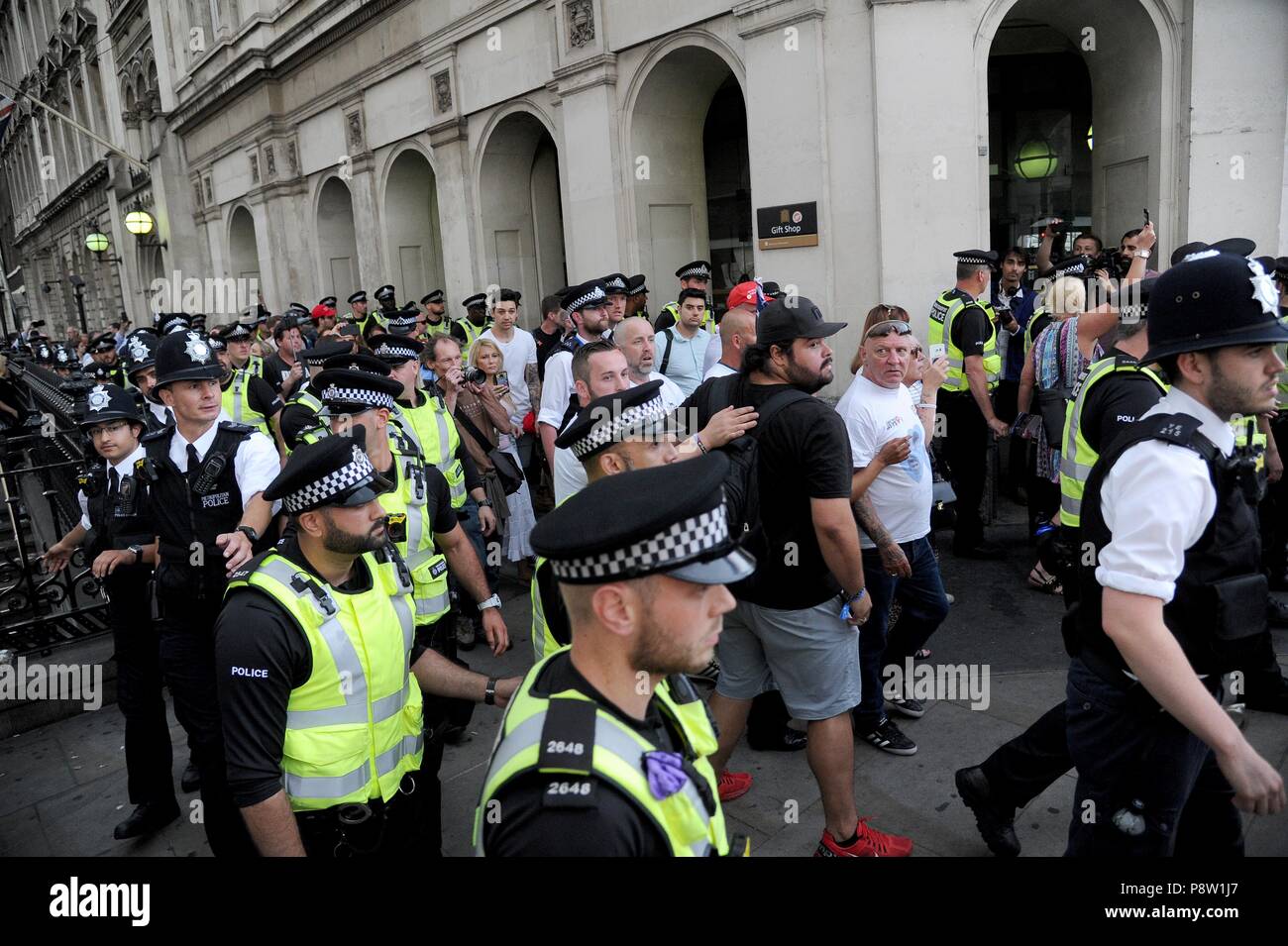 EDL supporters are escorted by police from The Red Lion pub during anti Trump protest march in Whitehall, London, UK Credit: Finnbarr Webster/Alamy Live News Stock Photo