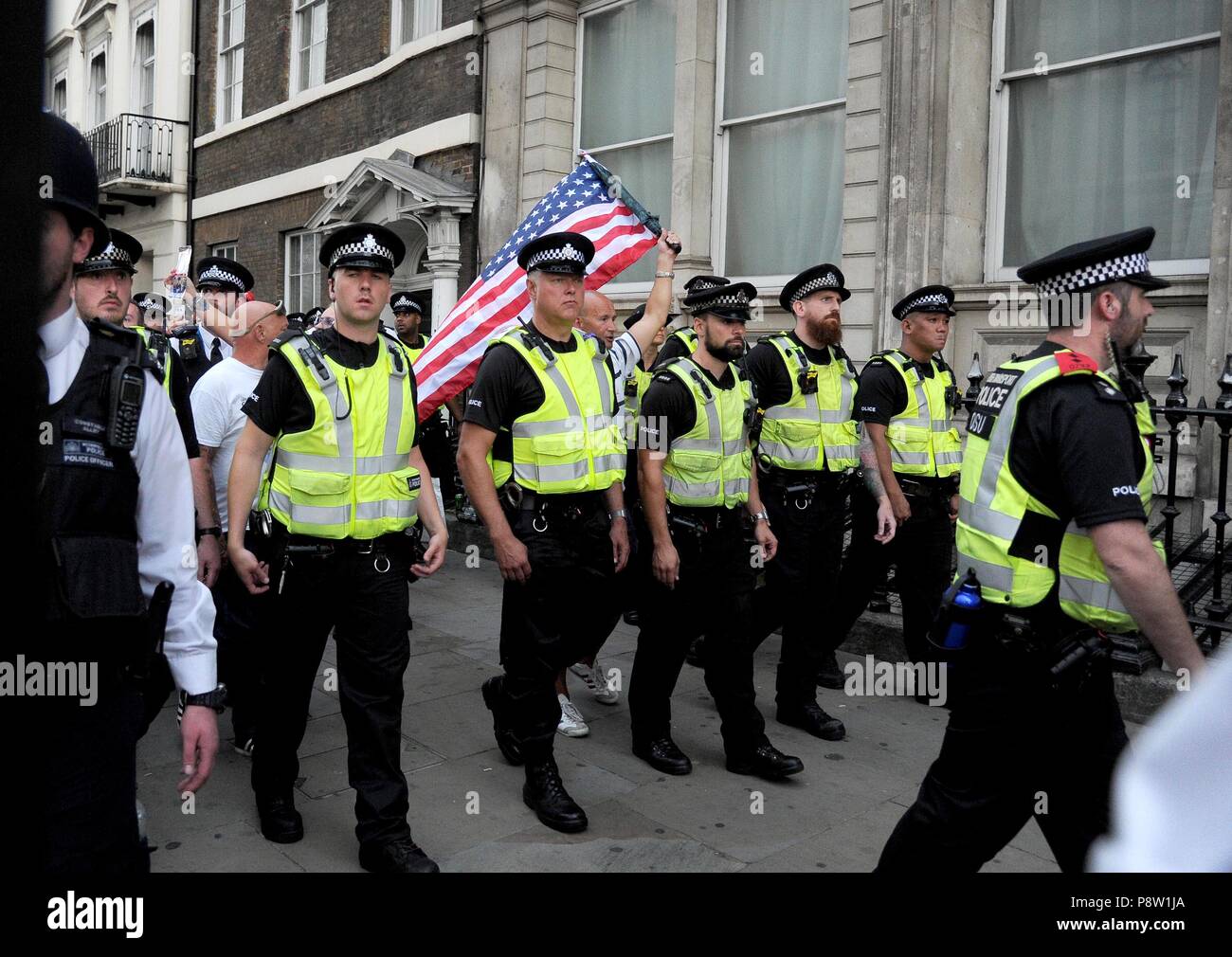 EDL supporters are escorted by police from The Red Lion pub during anti Trump protest march in Whitehall, London, UK Credit: Finnbarr Webster/Alamy Live News Stock Photo